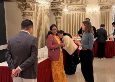 A reception hall filled with scientists engaging in lively academic discussion.