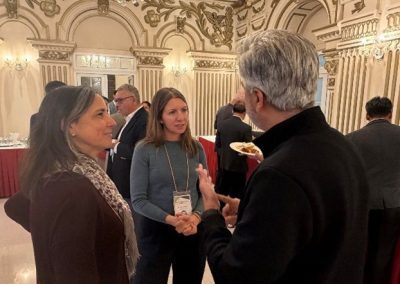 A reception hall filled with scientists engaging in lively academic discussion.